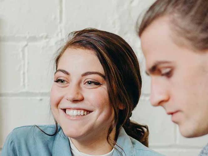 Man is focusing while the woman is smiling for a picture